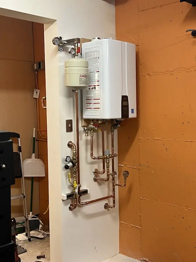 Plumbing technician inspecting water heater connections in Hasbrouck Heights